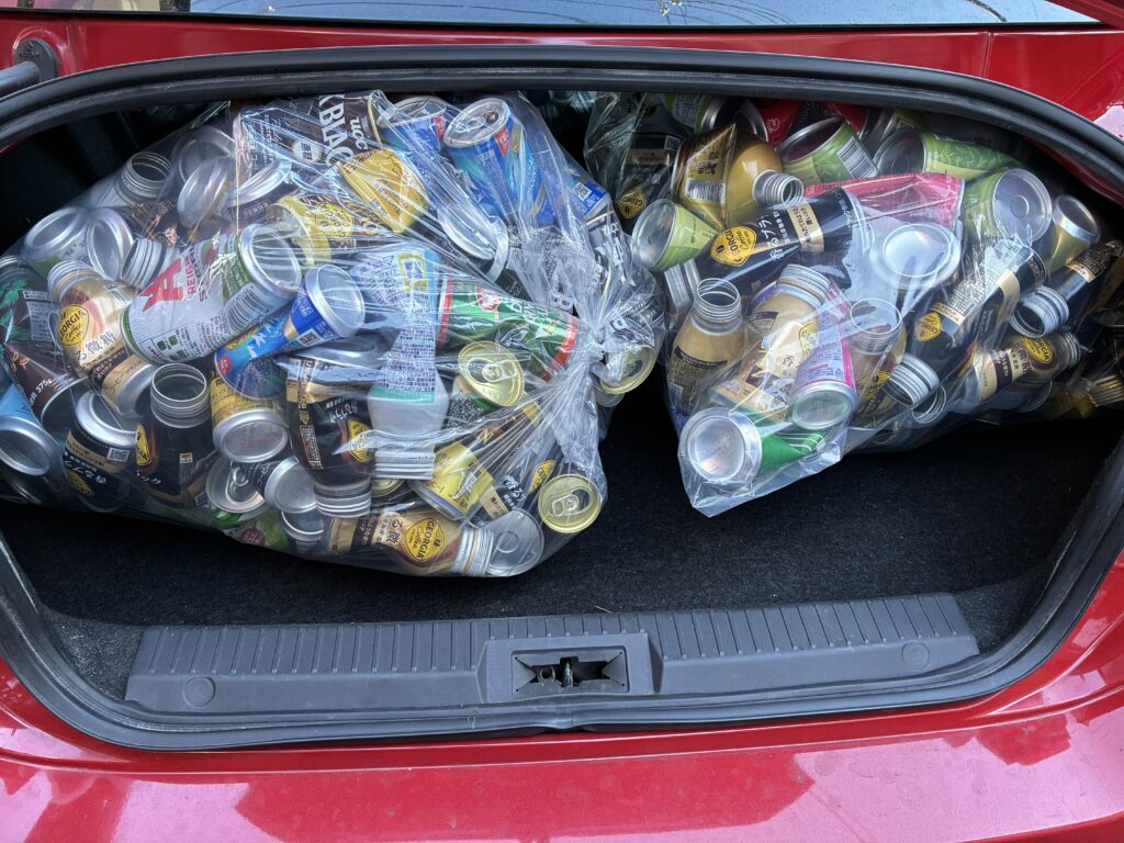 車のトランクに45Lポリ袋に入った缶を2袋積み込んだ様子。高さがギリギリで収納されている。